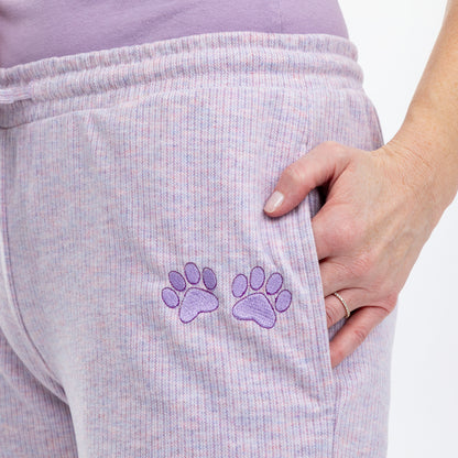 Close up of embroidered purple paw prints on the left leg of purple melange rib knit pants.