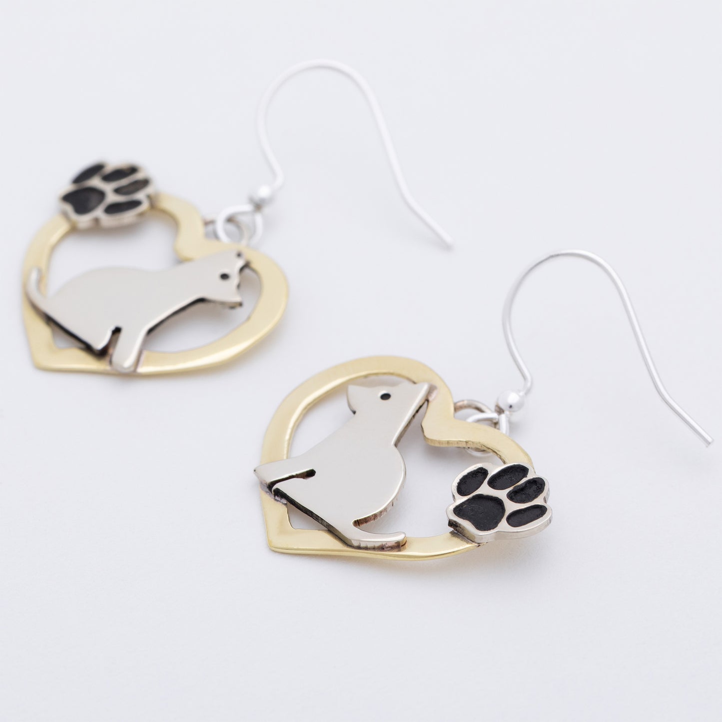 Heart-shaped earrings with a dog design and paw prints on a white background