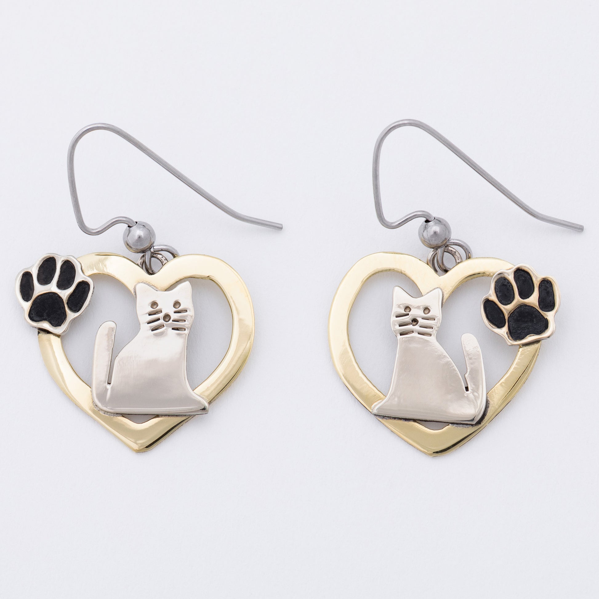 Cat-shaped earrings with heart designs on a white background