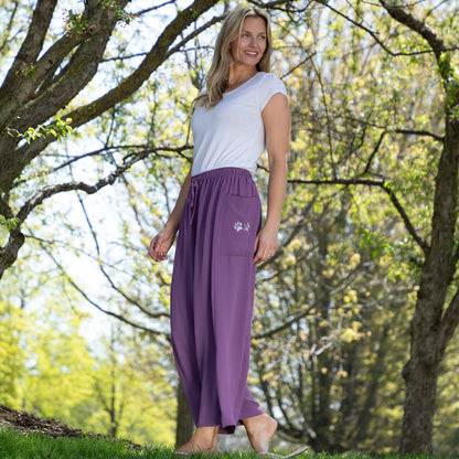Woman wearing purple pants with a paw print design outdoors