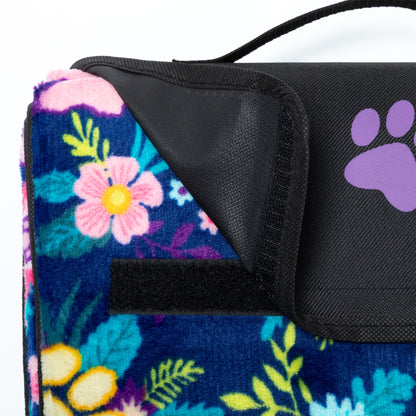 Floral-patterned blanket with a black closure/handle and purple paw print on a white background.