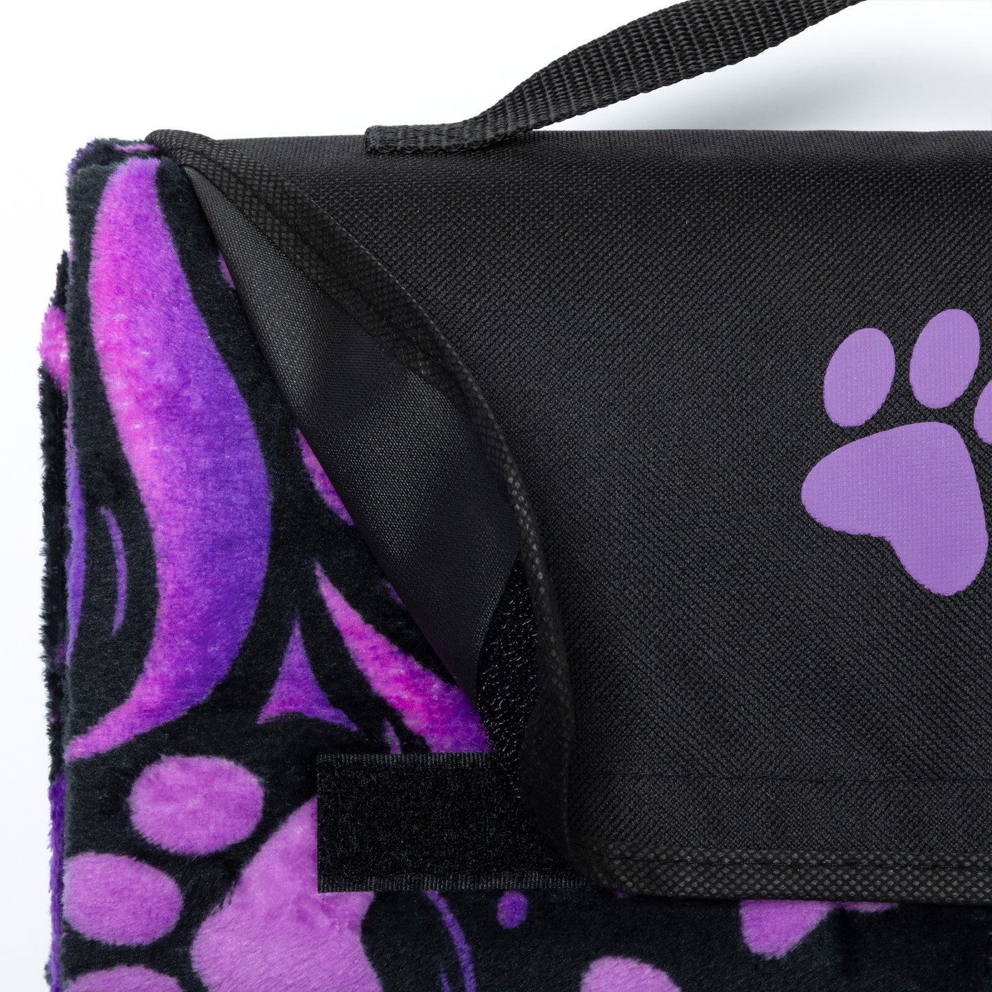 Black and purple paw print blanket with a strap on a white background.