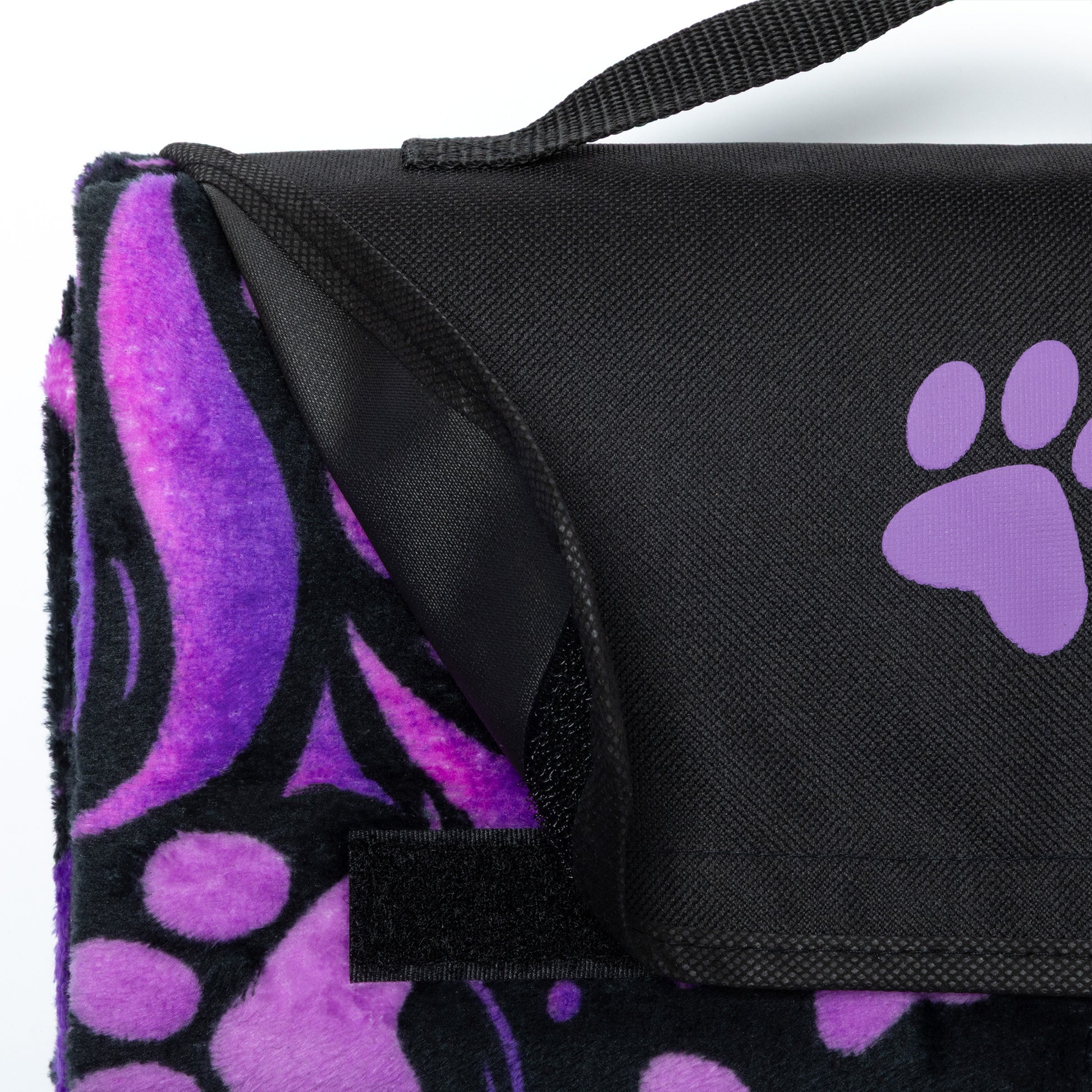 Black and purple paw print blanket with a strap on a white background.