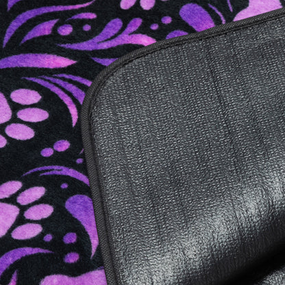Black textured waterproof backing on a purple and black patterned fleece blanket.