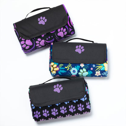Three folded picnic blankets with paw print and floral patterns on a white background