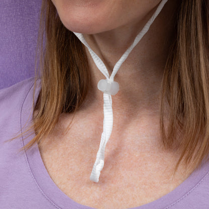 Close-up of a person wearing an adjustable toggle on their neck against a purple background.