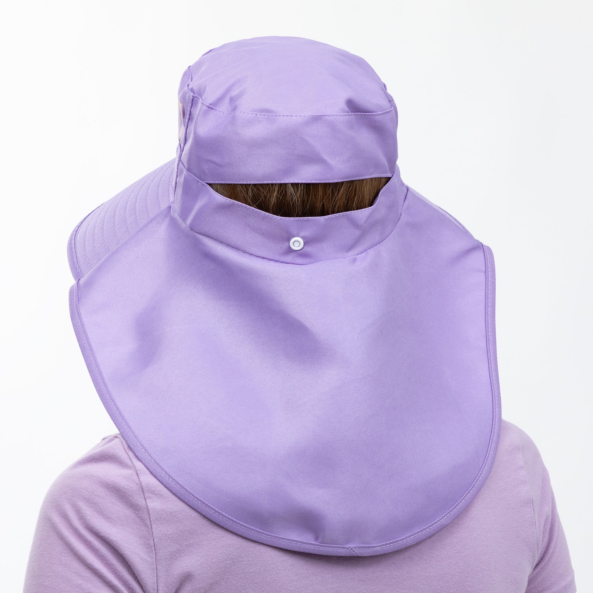 Person wearing a light purple neck flap on a sun hat on a white background