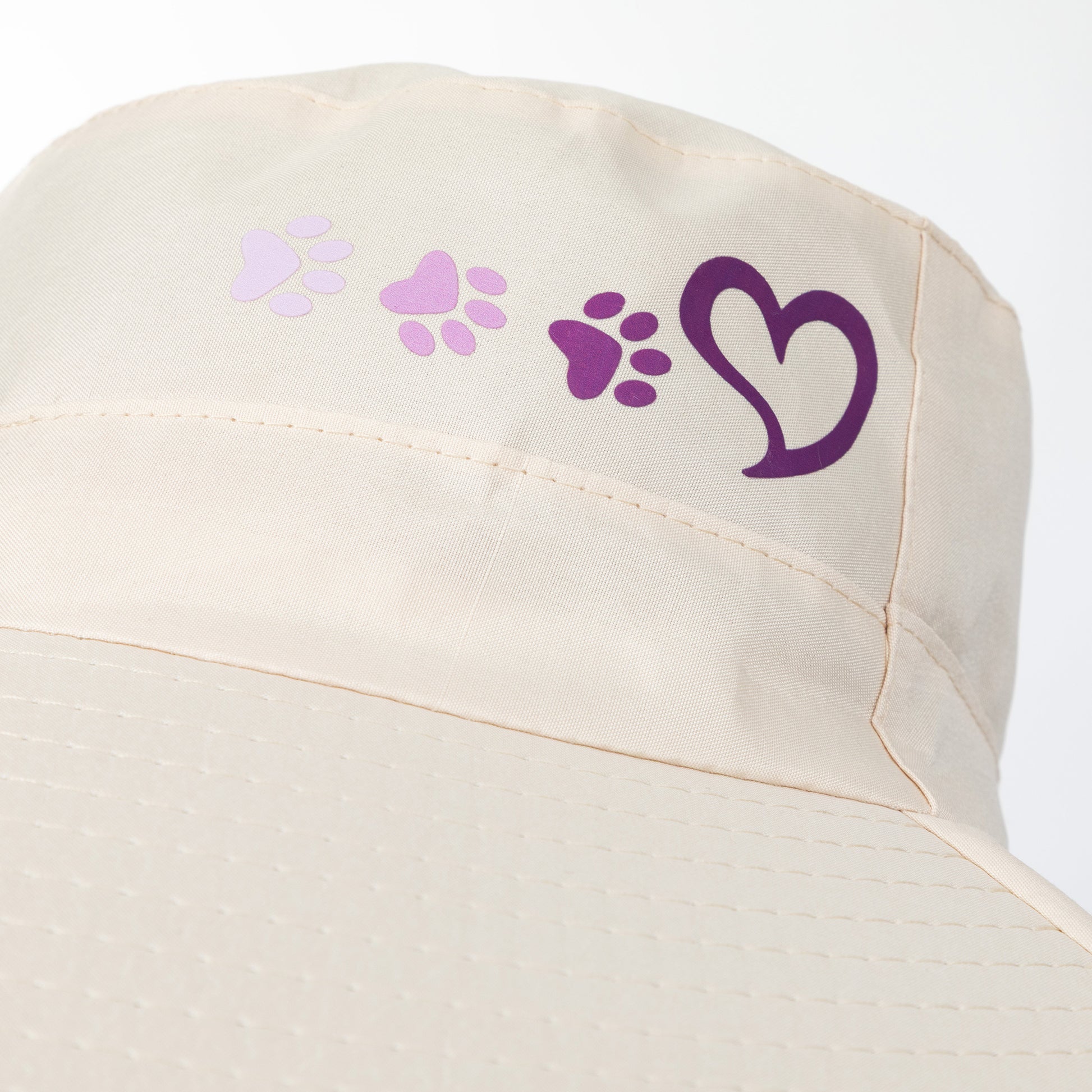 Beige sun hat with purple paw prints and heart design on a white background