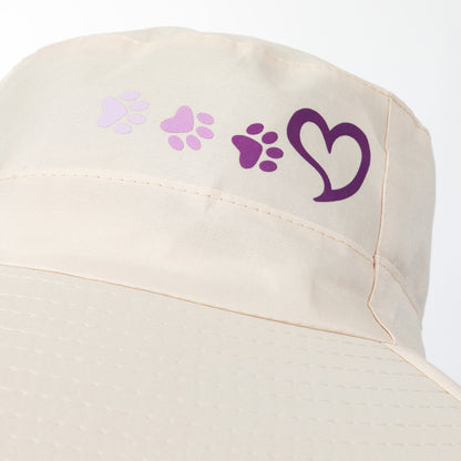 Beige sun hat with purple paw prints and heart design on a white background