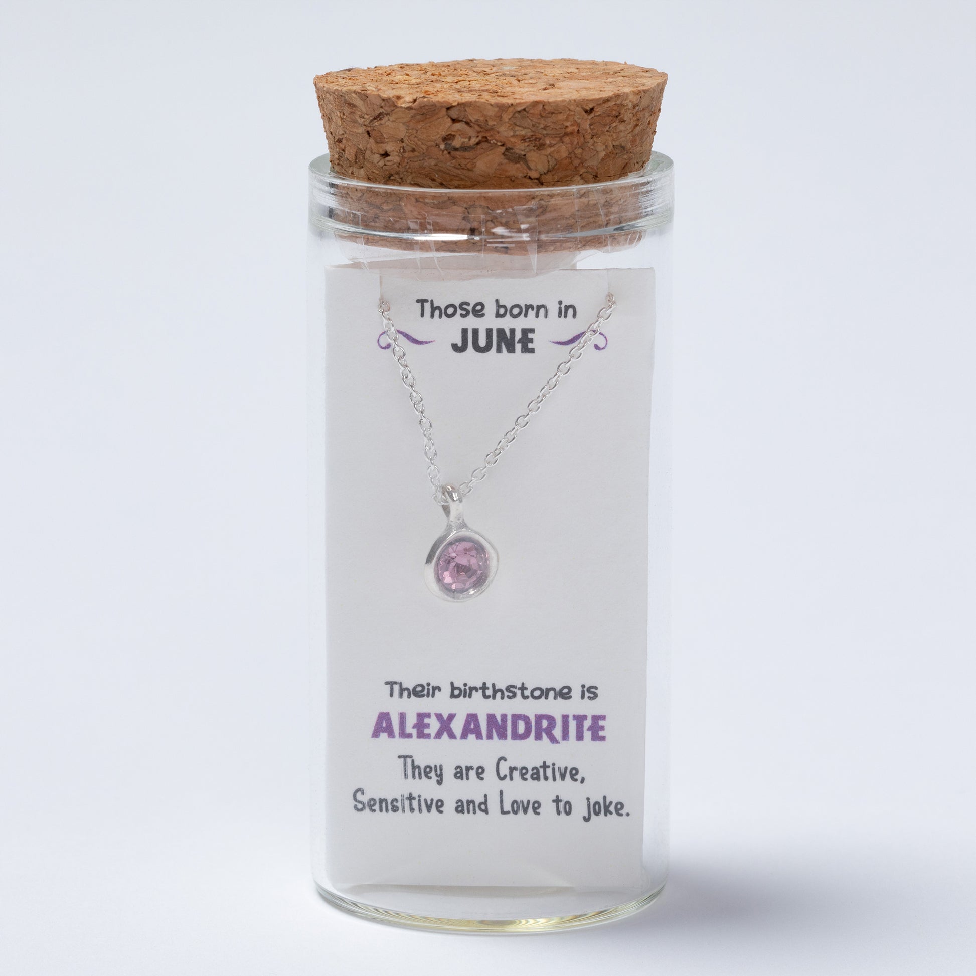 Necklace in a glass jar with cork lid on a white background