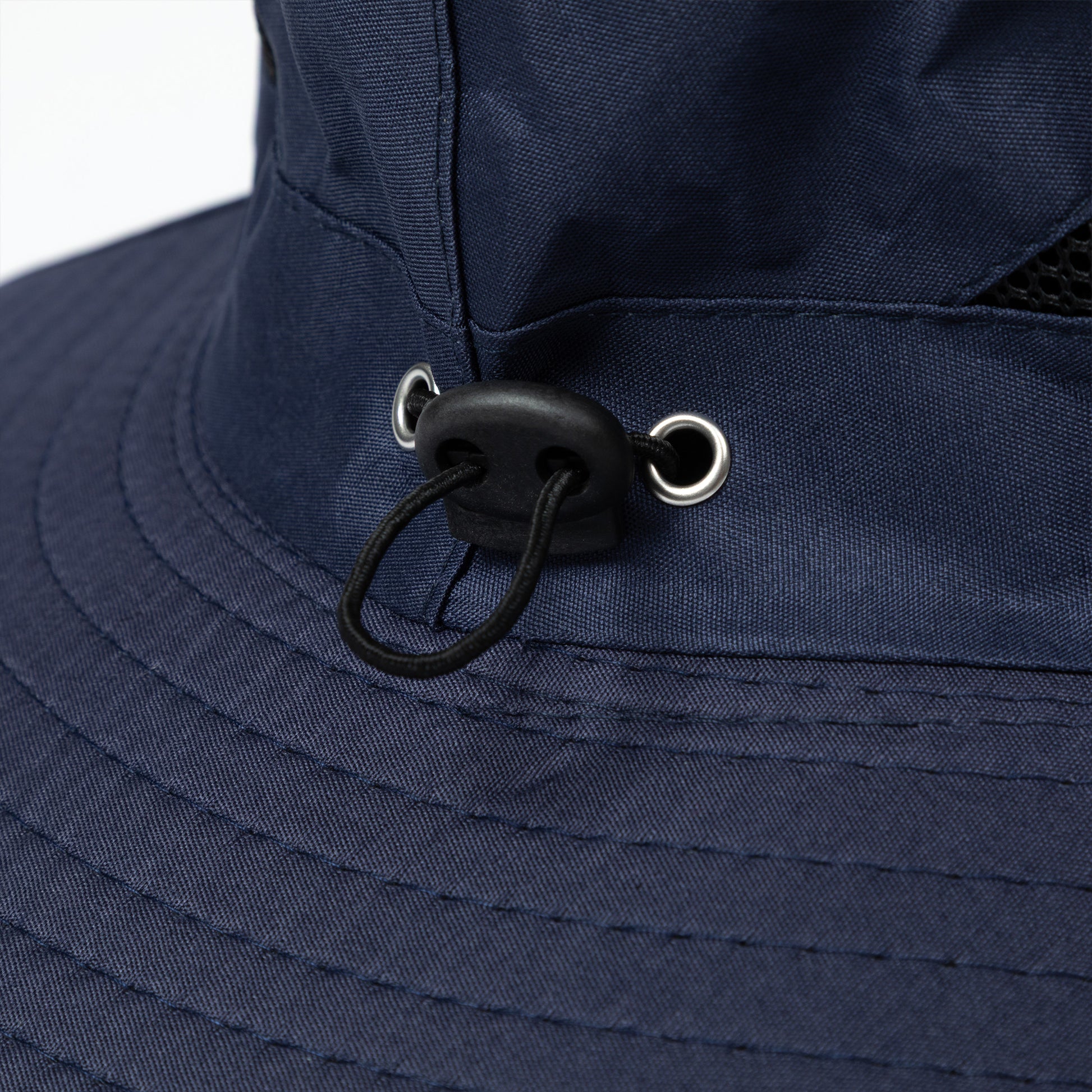 Close-up of a navy blue bucket hat with a chin strap on a white background