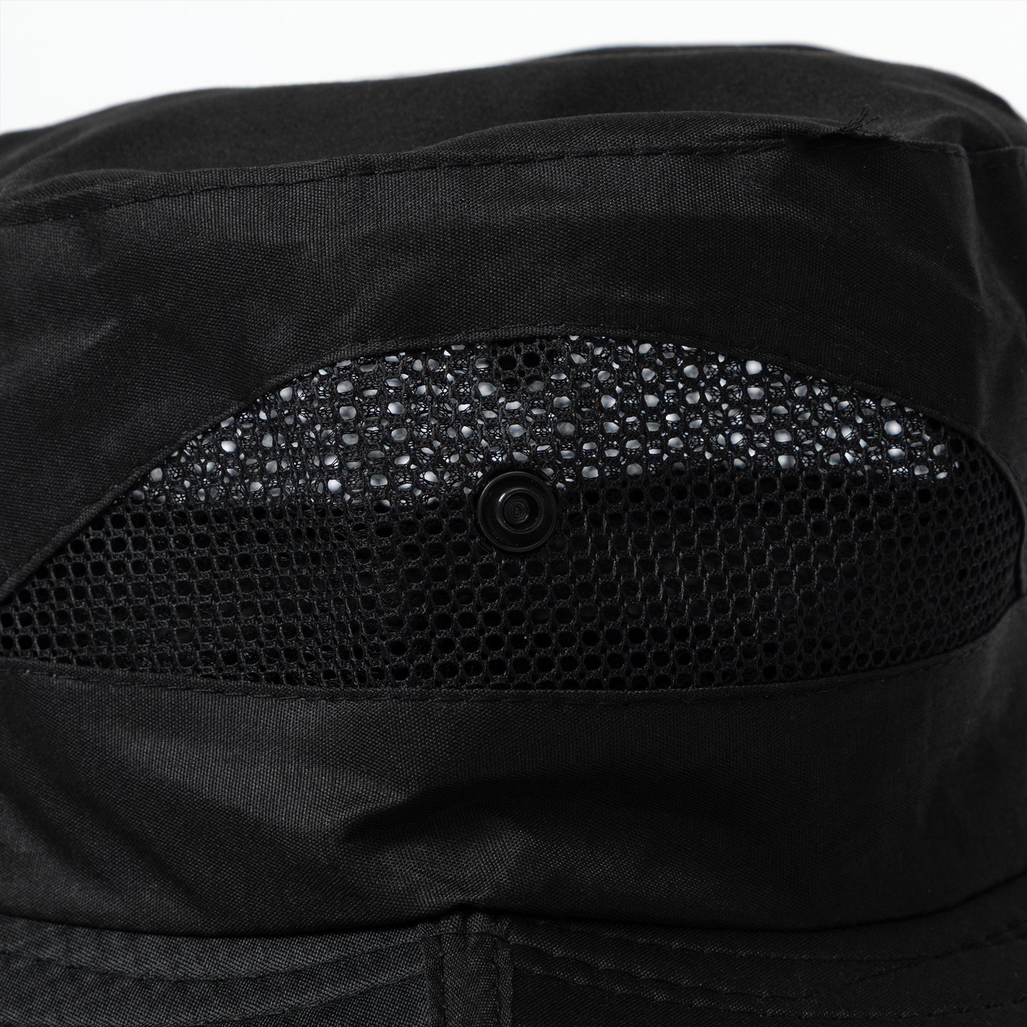 Close-up of a black sun hat with vented sides and button snaps for adjustability.