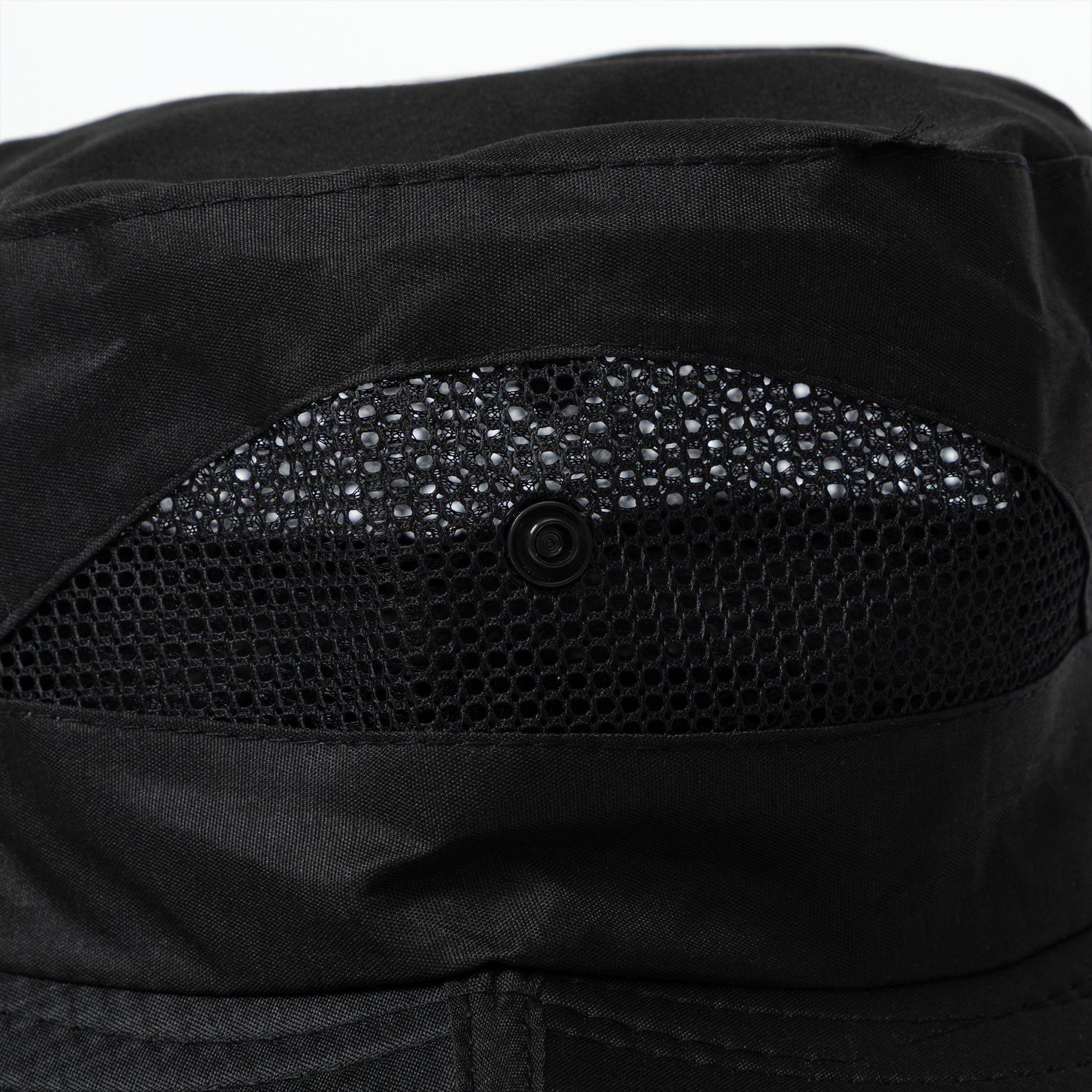 Close-up of a black sun hat with vented sides and button snaps for adjustability.