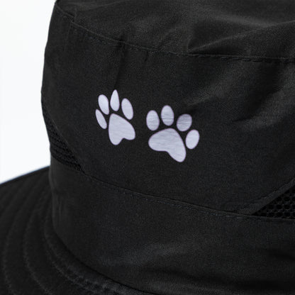 Black sun hat with white paw prints on a white background