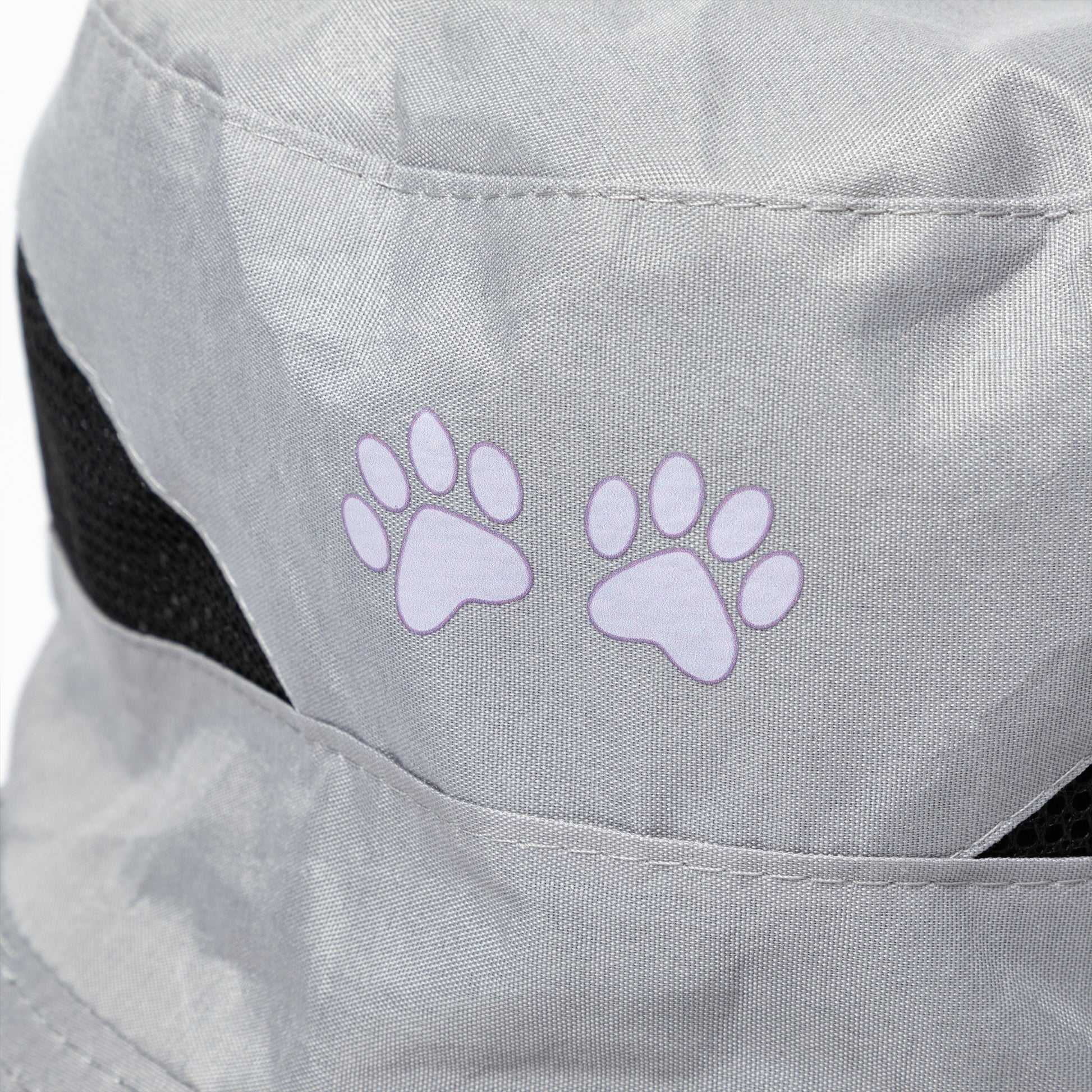 Gray sun hat with purple paw prints on a close-up of the fabric.