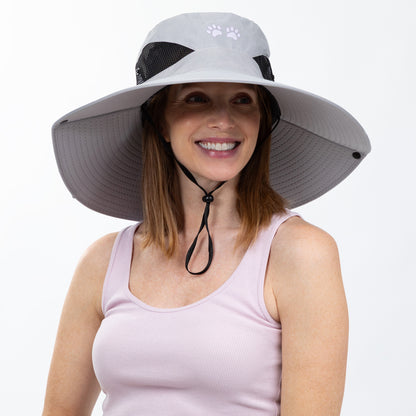 Woman wearing a wide-brimmed sun hat with a paw print design on a white background