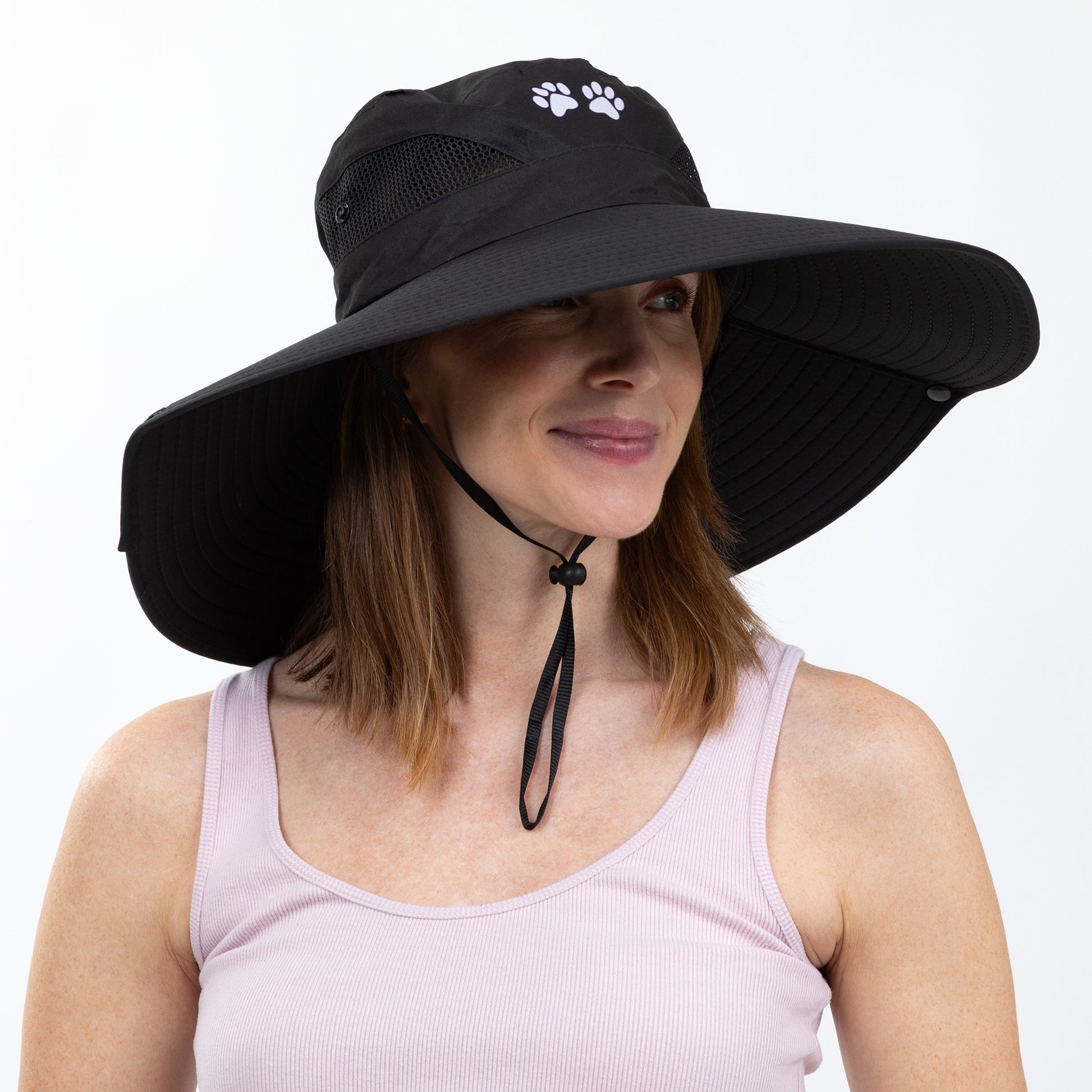 Woman wearing a black wide-brimmed hat with a paw print design on a white background