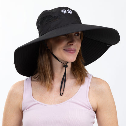 Woman wearing a black wide-brimmed hat with a paw print design on a white background