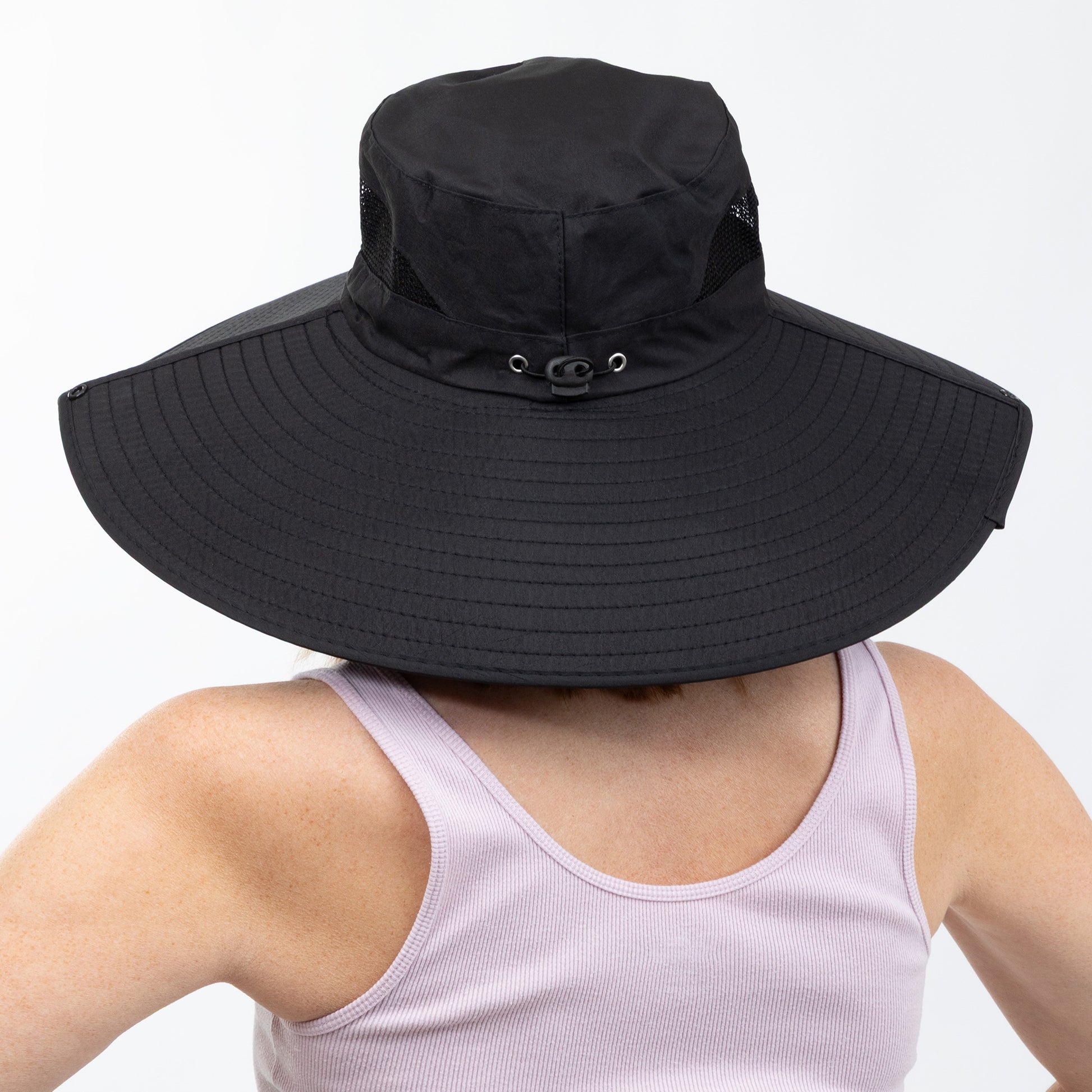 Back of a Black wide-brimmed hat worn by a person on a white background