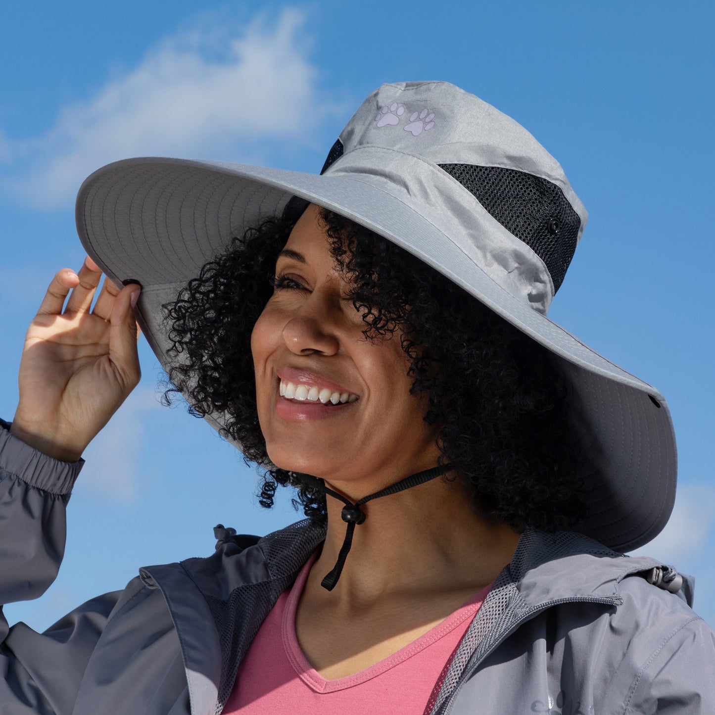 Woman wearing a gray wide-brimmed hat against a blue sky