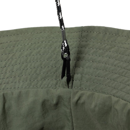 Close-up of a green bucket hat with adjustable chin strap on white background