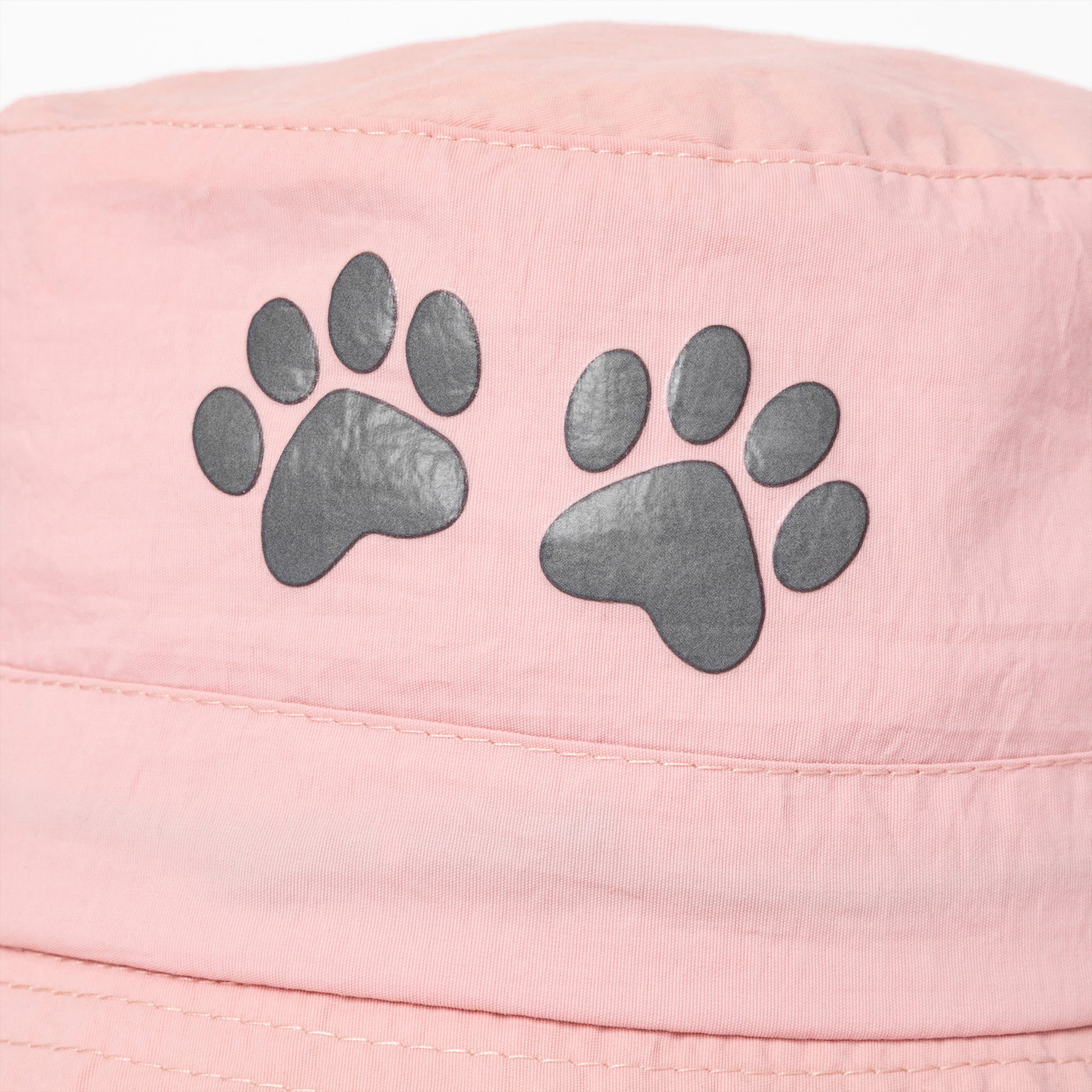 Pink bucket hat with gray paw prints on a white background
