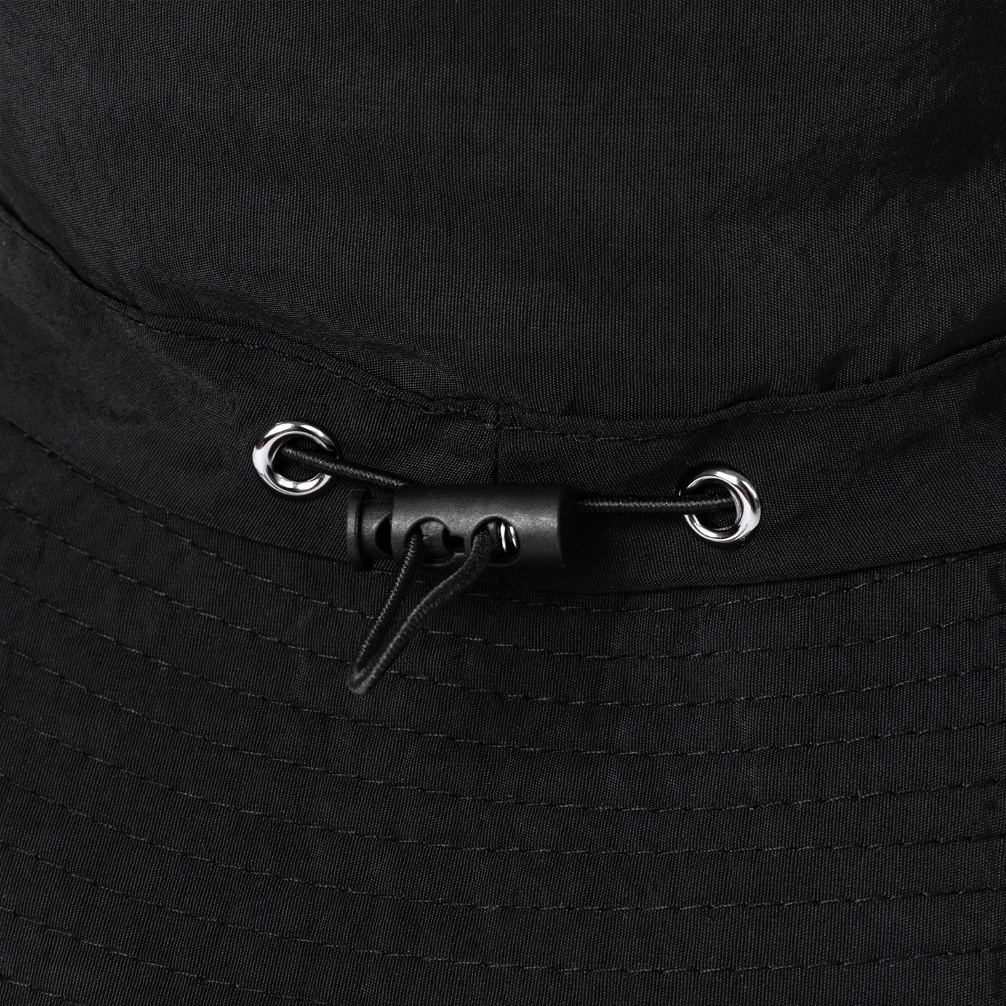 Close-up of a black bucket hat with toggle for adjustable fit