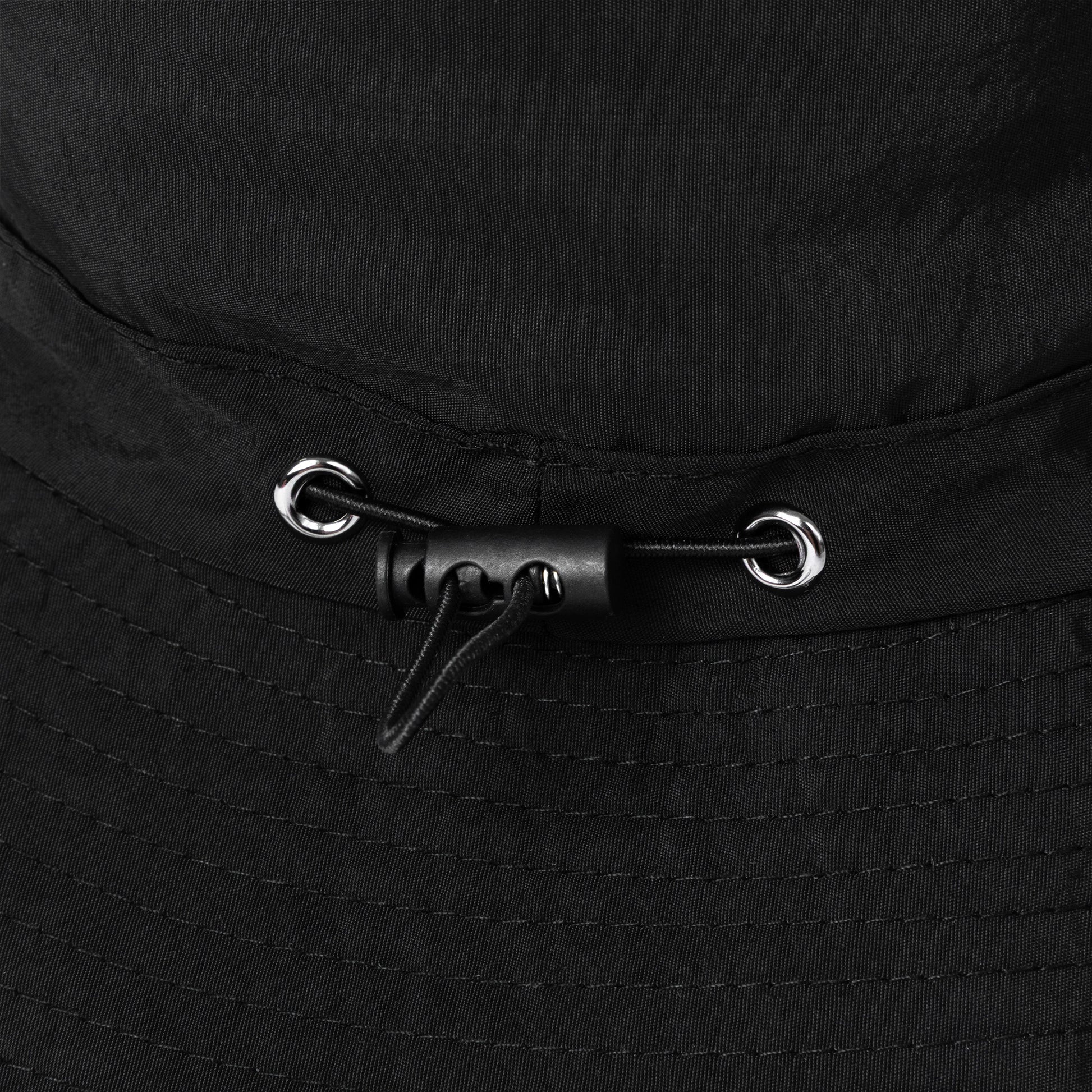 Close-up of a black bucket hat with toggle for adjustable fit
