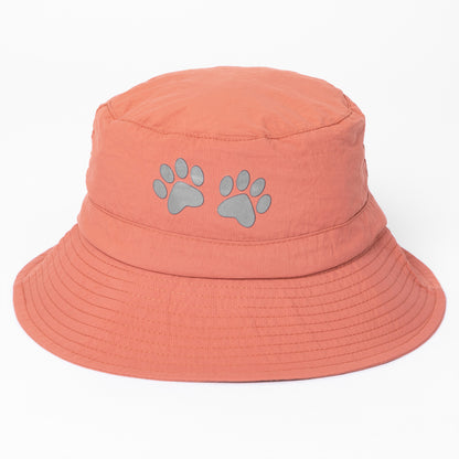 Coral bucket hat with paw prints on a white background