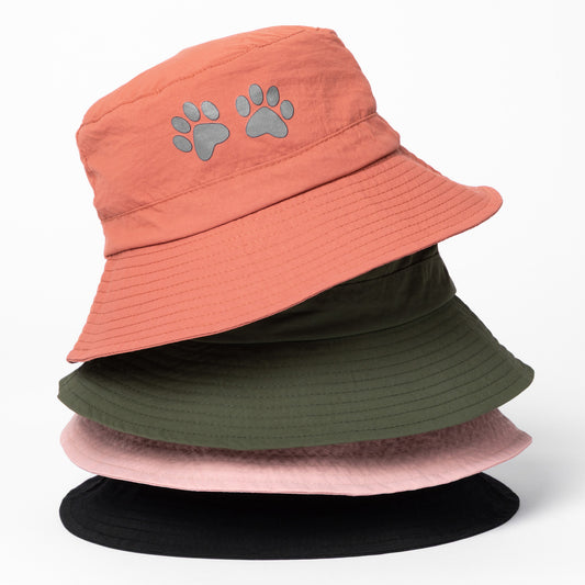 Stack of four bucket hats in different colors with paw prints on a white background