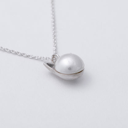Silver necklace with a unique pendant on a light gray background