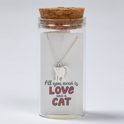 Cat-themed necklace in a glass jar with cork lid on a white background