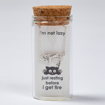 Cat-themed necklace in a glass jar with cork lid on a light gray background