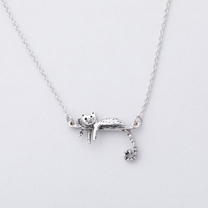 Silver cat-shaped pendant on a chain against a light gray background