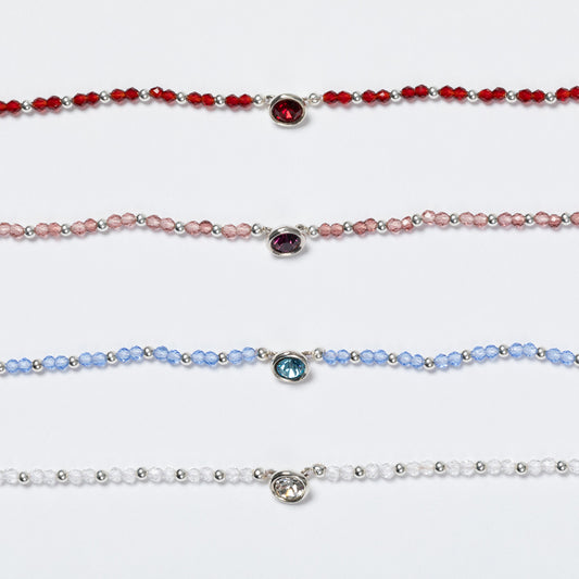 Four beaded bracelets with colored gemstones on a white background