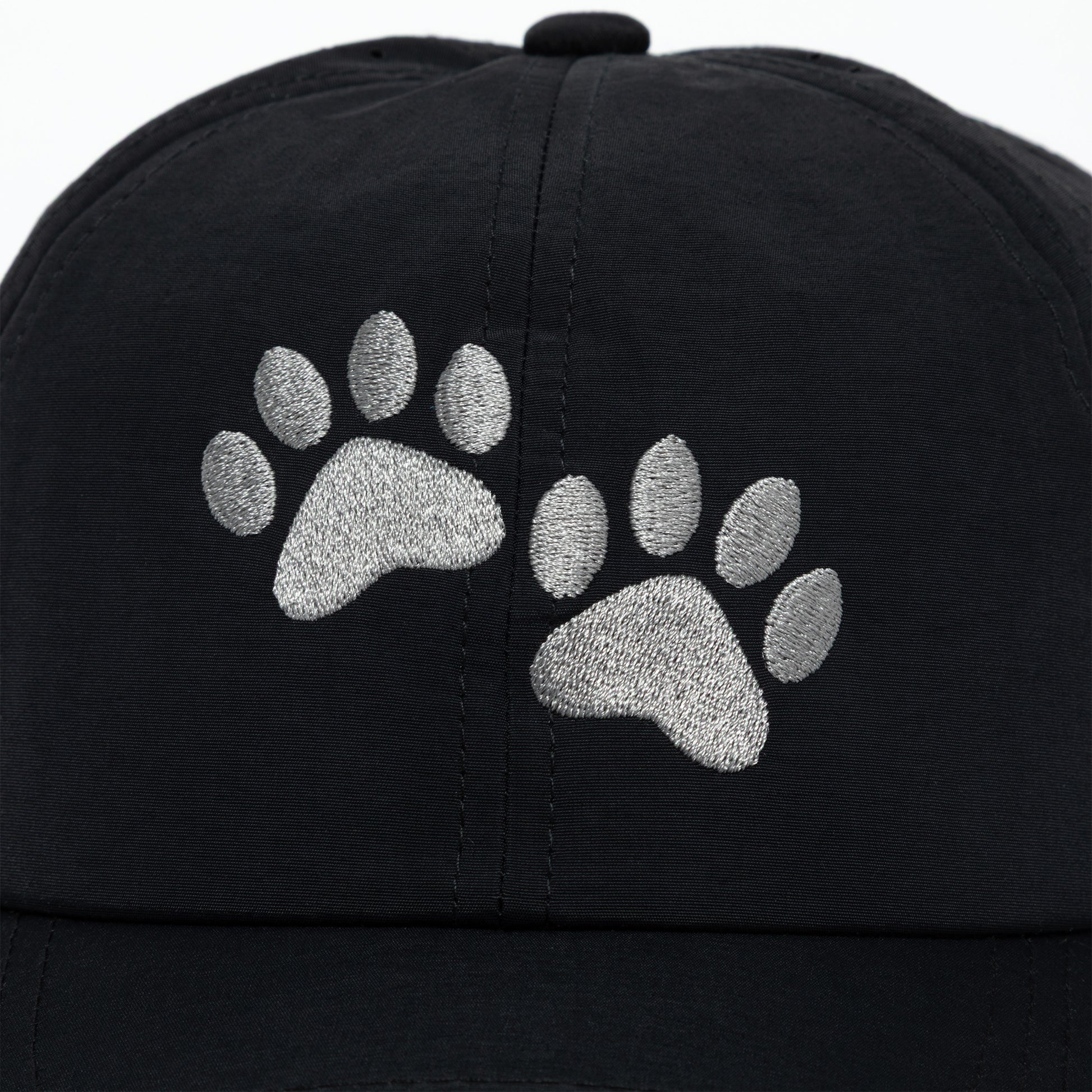 Black cap with silver paw prints on a white background