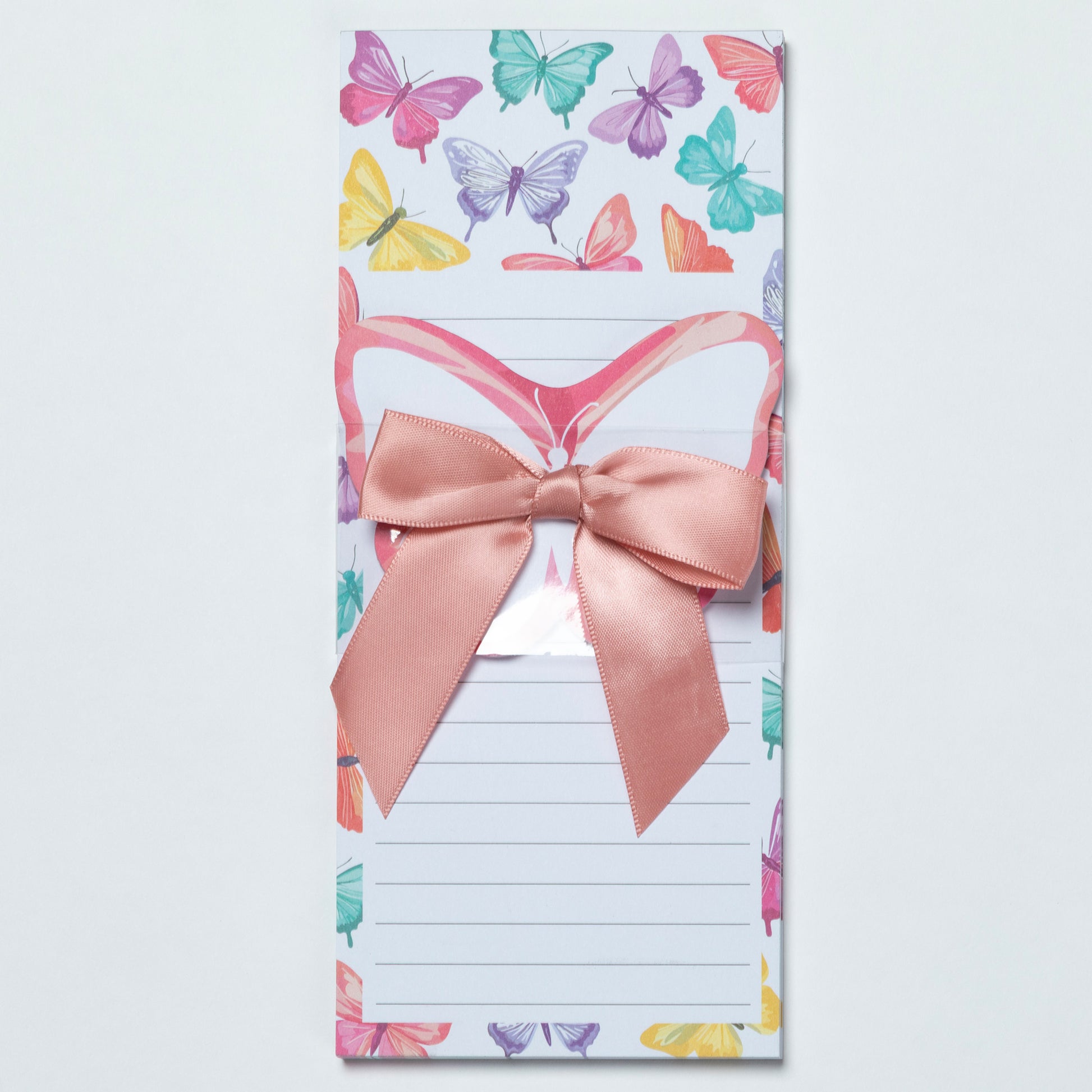 Notepad with colorful butterfly design and a pink bow on a white background