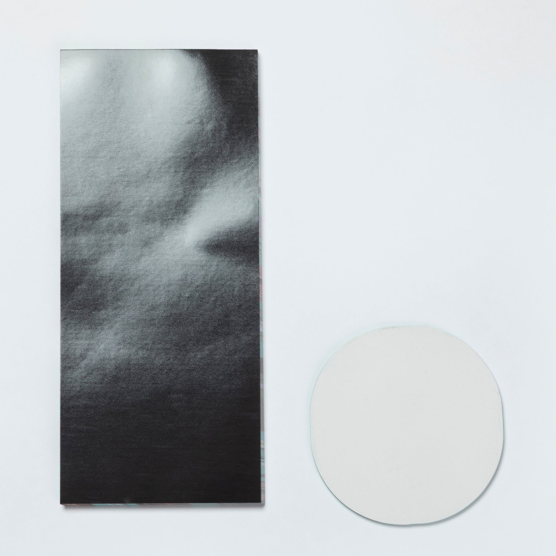 Magnetic backing of a notepad and the plain backing of a sticky note set.