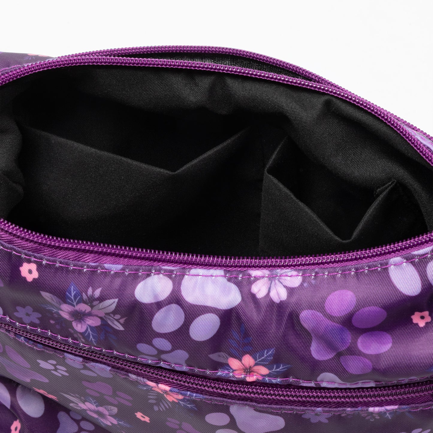 Close-up of a purple zippered pouch with a floral and paw-print pattern, showing the black interior lining and zipper details.