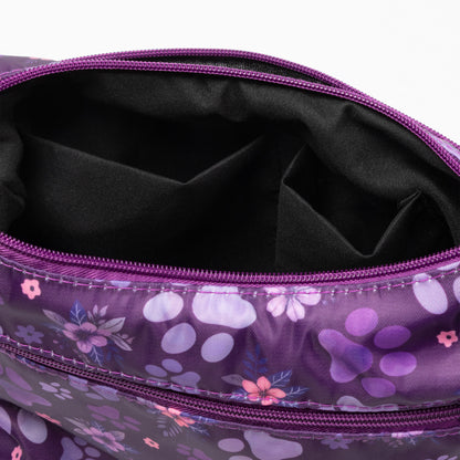 Close-up of a purple zippered pouch with a floral and paw-print pattern, showing the black interior lining and zipper details.