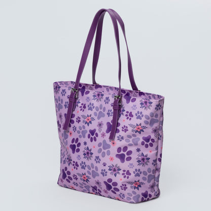 Purple tote bag with paw print pattern on a light gray background