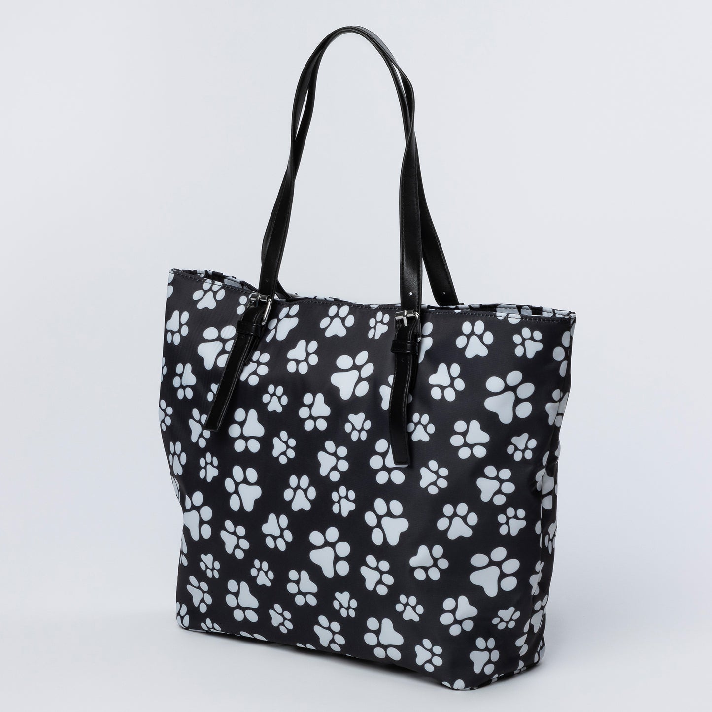 Black tote bag with white paw print pattern on a light gray background