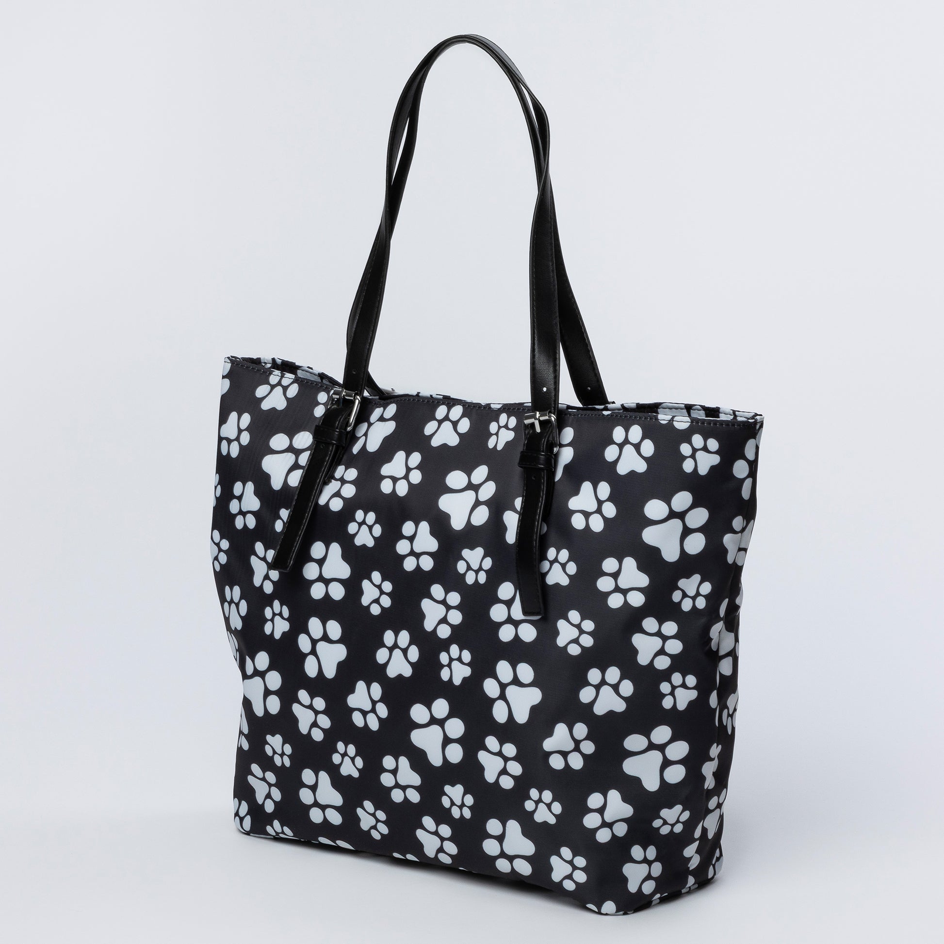 Black tote bag with white paw print pattern on a light gray background