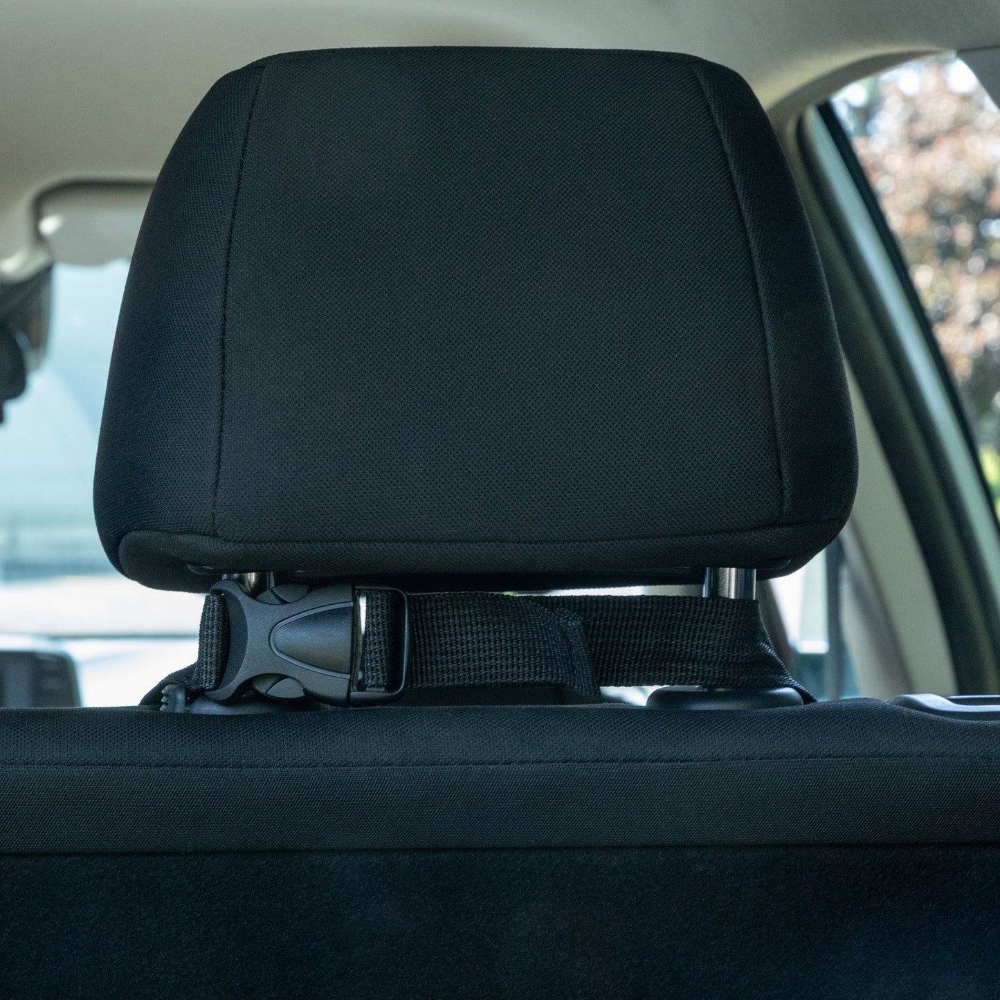 Car headrest with a seatbelt buckle in a vehicle interior
