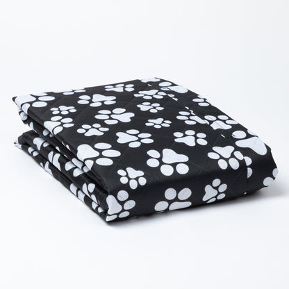 Folded black car seat cover with white paw prints on a white background