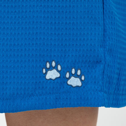 Blue shorts with embroidered light blue paw prints on a textured fabric background