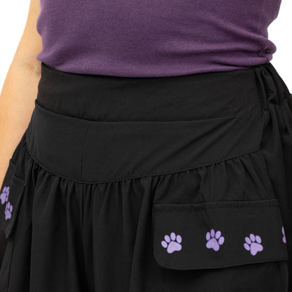 Black shorts with purple paw prints worn by a person in a purple shirt.