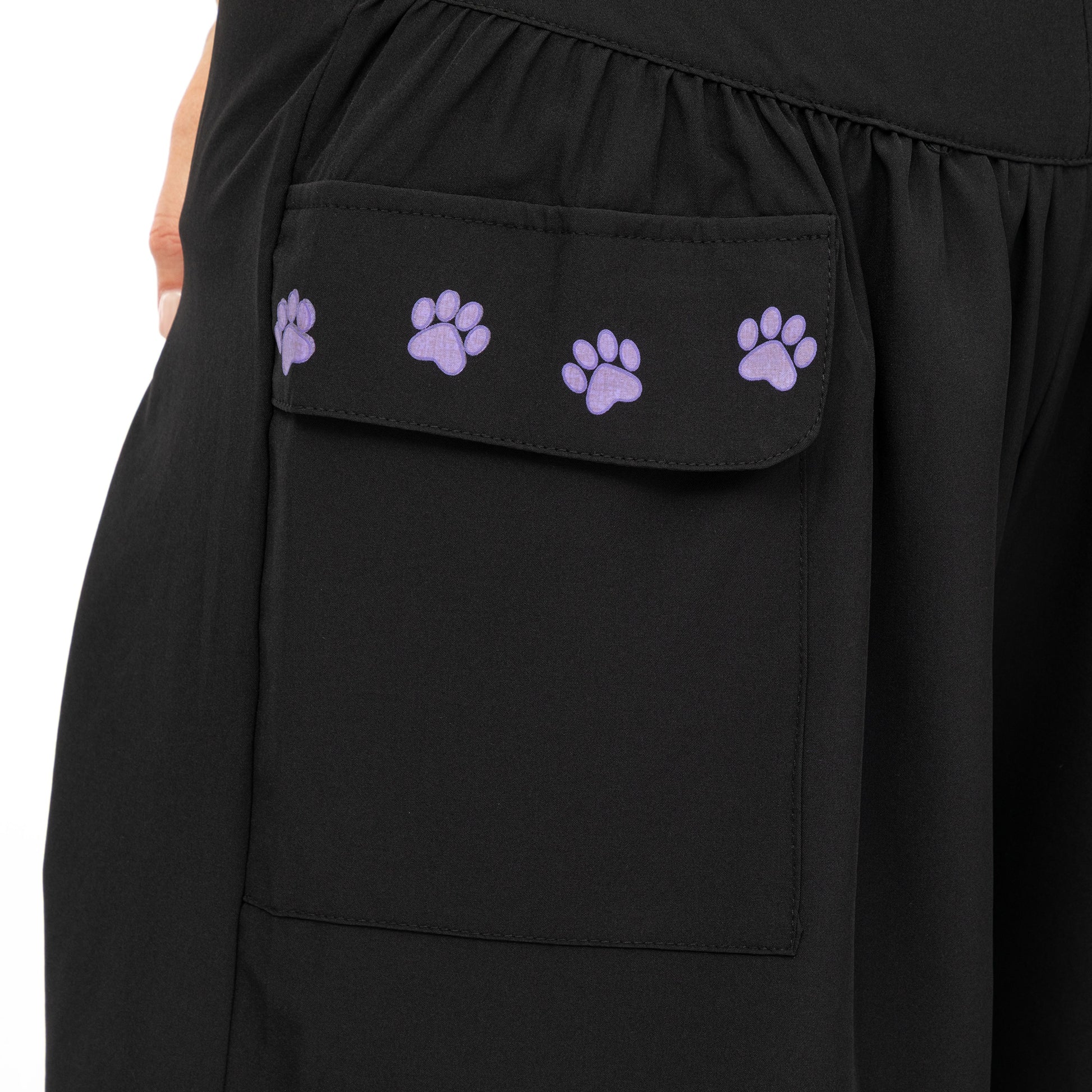 Close up of black shorts with cargo pocket featuring small purple paws on the foldover pocket