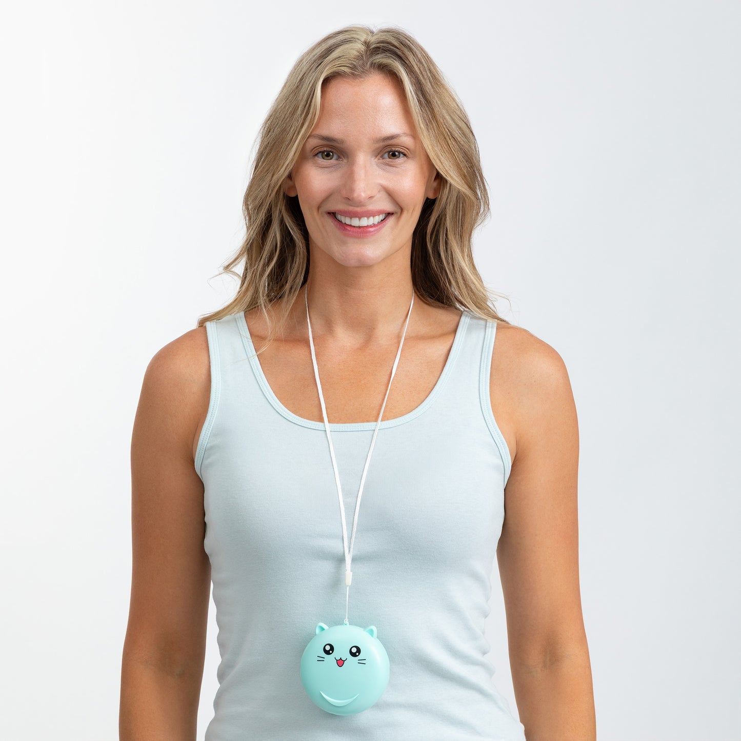 A smiling woman wearing a light blue tank top and a white cord necklace with a round mint-green cat-shaped mini fan, set against a plain light gray studio background.