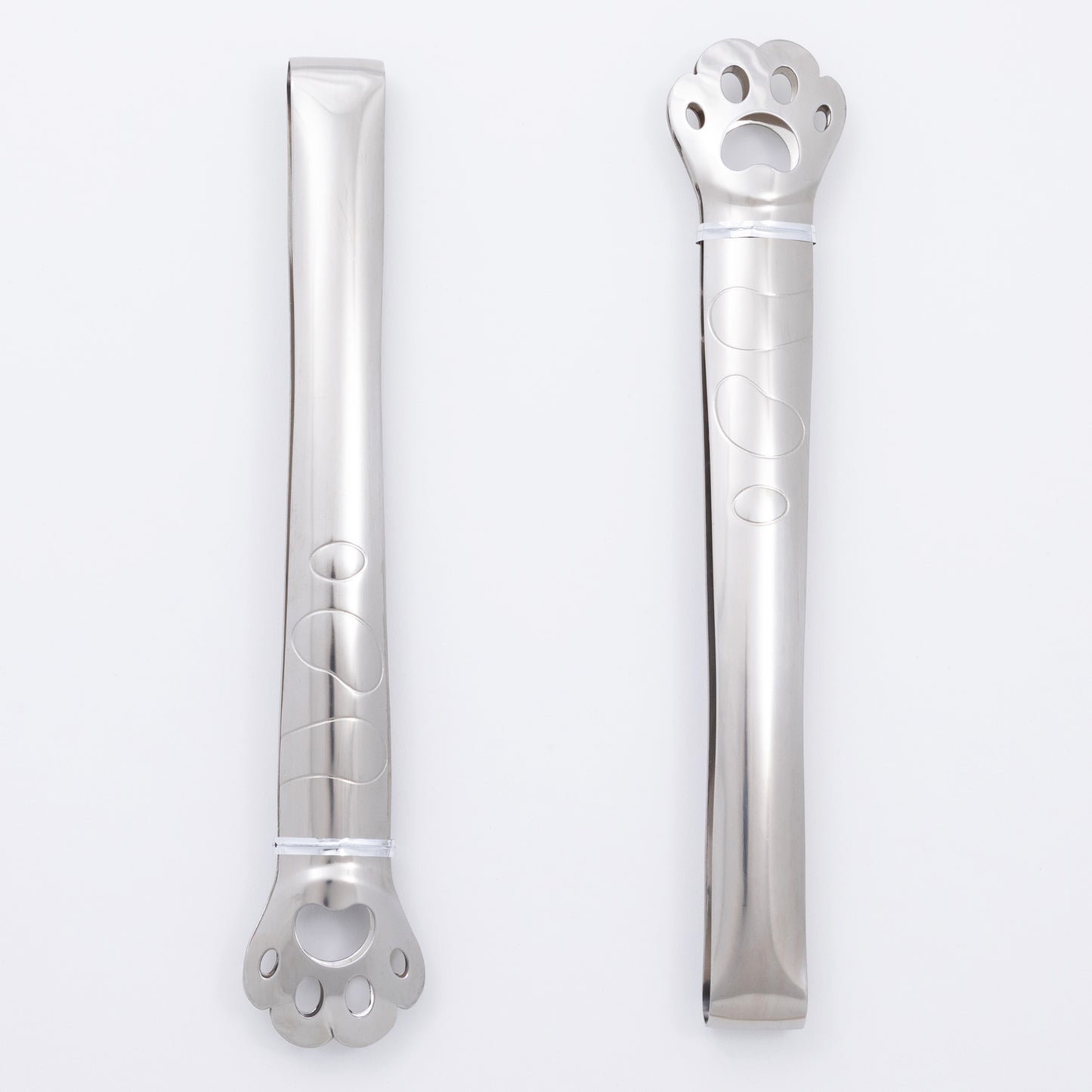 Two stainless steel paw print tongs on a white background
